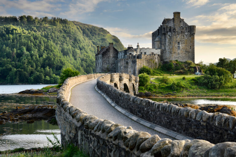 Evening light on restored Eilean Donan Castle on Island at three lochs with added stone arch footbridge Scottish Highlands Scotland UK