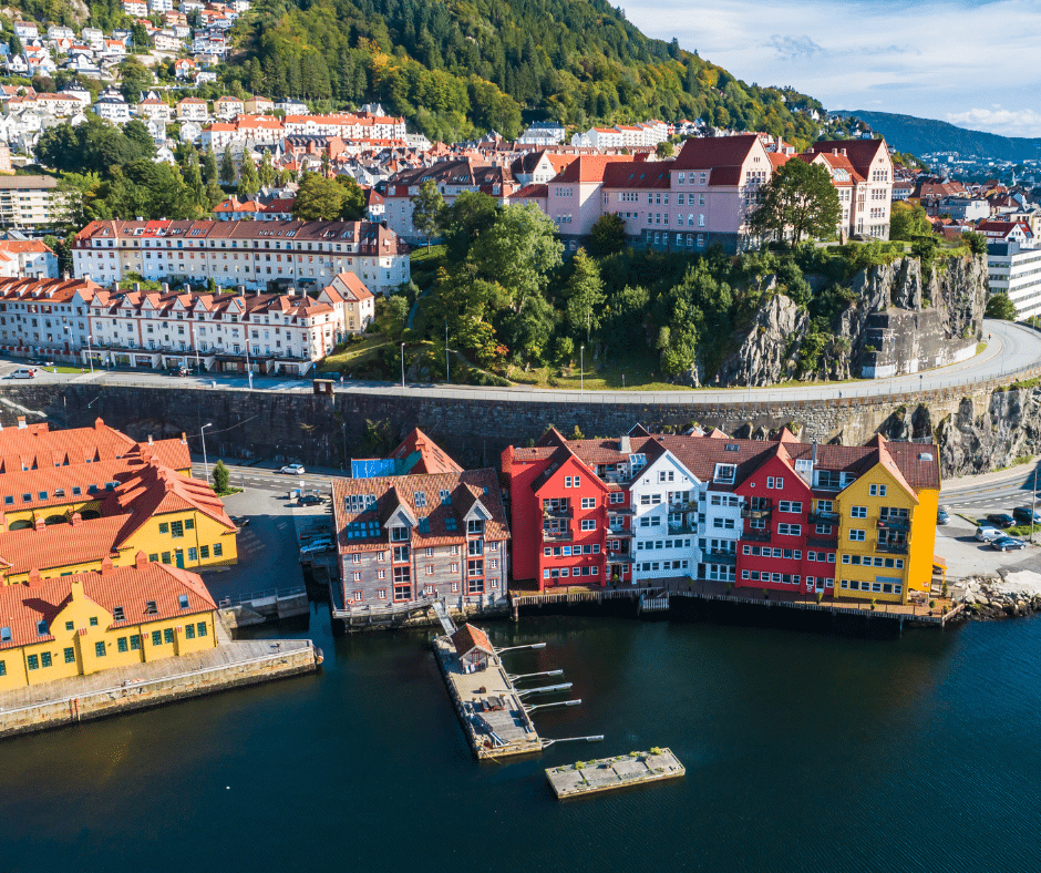 Colorful wooden houses along Bryggen Wharf with mountains in the background in Bergen, Norway