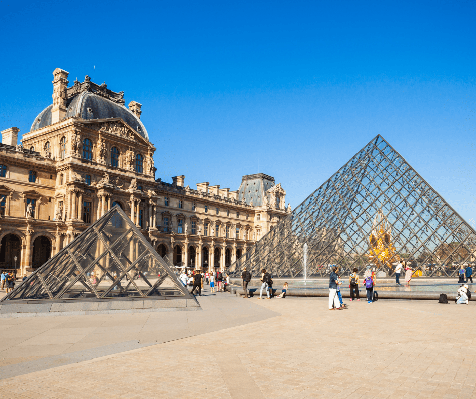 exterior of Louvre museum, and its pyramid in the center of Paris France