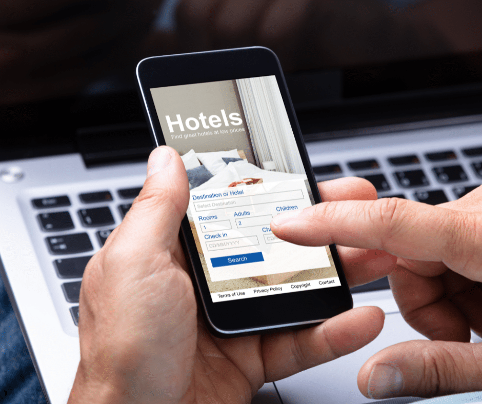 Traveler booking a hotel on a smartphone for a last-minute winter trip to Milan–Cortina 2026