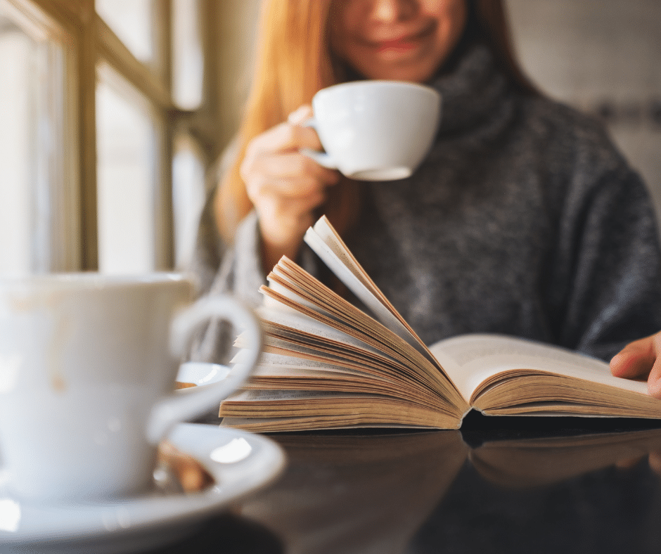 Person reading a book with coffee in soft morning light, capturing the relaxed pace of a European weekend escape