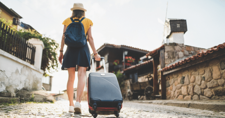 Tourist couple with luggage on a cobblestone street in Europe, highlighting common Europe travel mistakes